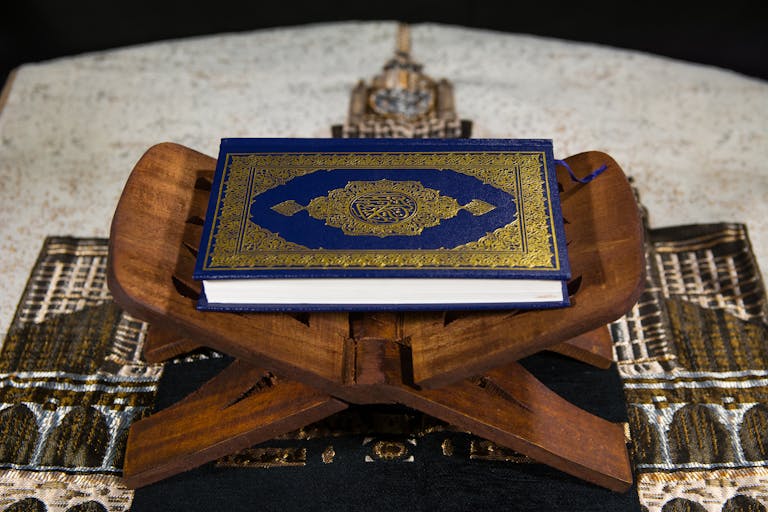 Close-up of the Quran on a wooden stand, symbolizing Islamic spirituality.